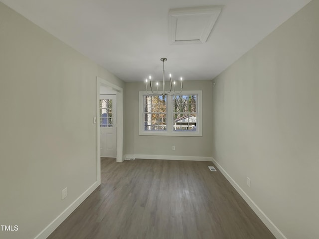 unfurnished dining area with wood-type flooring and a notable chandelier