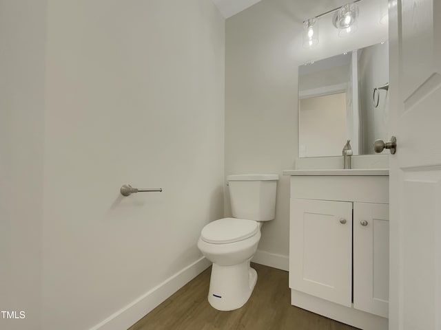 bathroom with vanity, hardwood / wood-style flooring, and toilet