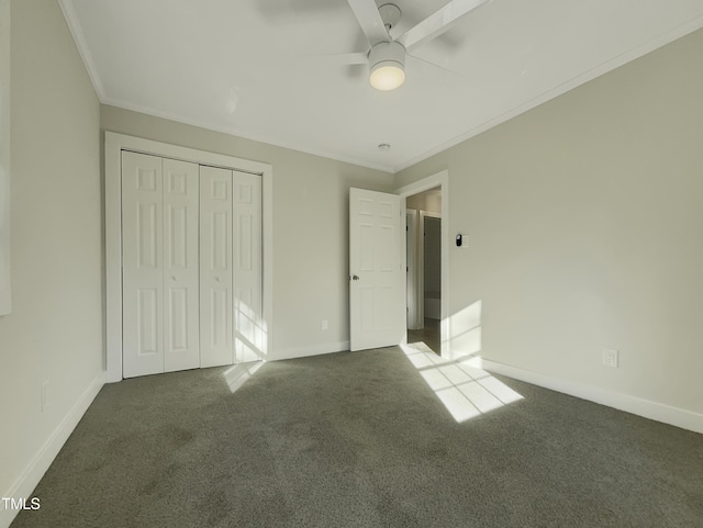 unfurnished bedroom featuring dark colored carpet, ceiling fan, crown molding, and a closet