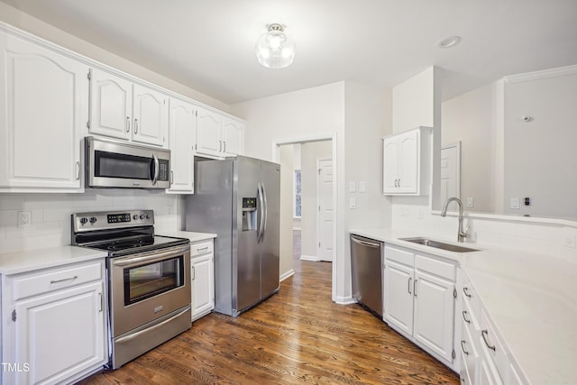 kitchen with backsplash, stainless steel appliances, sink, white cabinets, and dark hardwood / wood-style floors