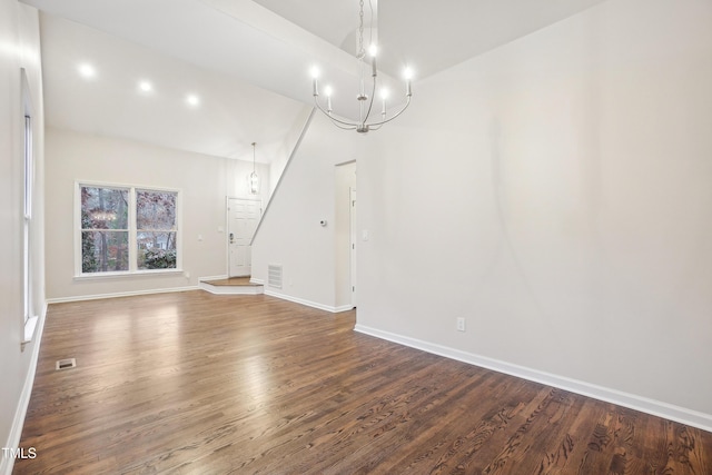 unfurnished living room with wood-type flooring and an inviting chandelier