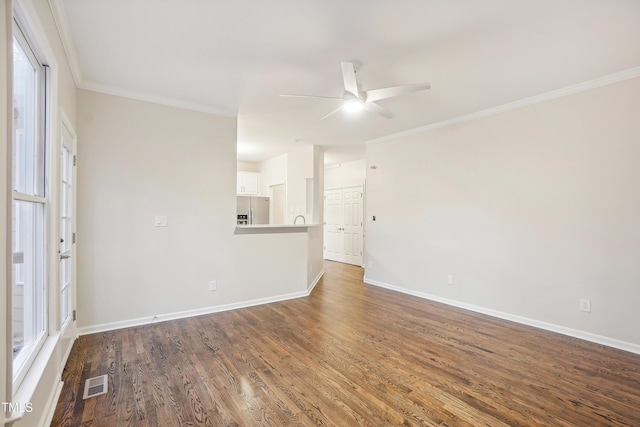 empty room featuring crown molding, plenty of natural light, ceiling fan, and wood-type flooring