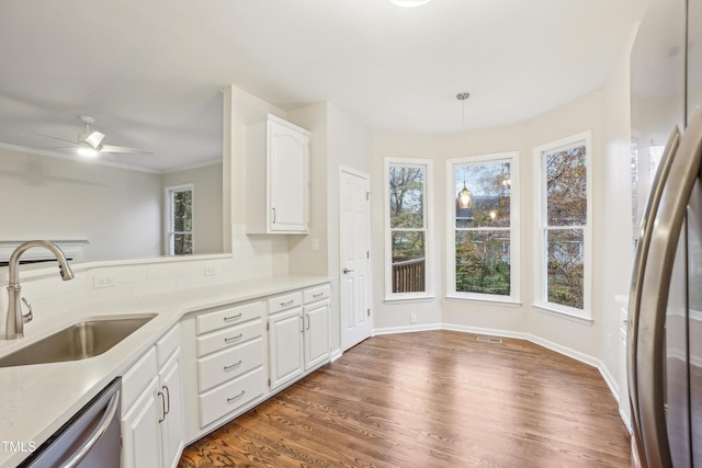 kitchen with stainless steel appliances, sink, decorative light fixtures, dark hardwood / wood-style floors, and white cabinetry