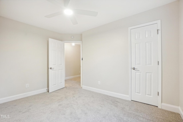 unfurnished bedroom with ceiling fan and light colored carpet