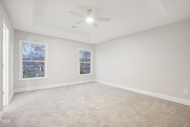 unfurnished room featuring carpet flooring, ceiling fan, and a tray ceiling