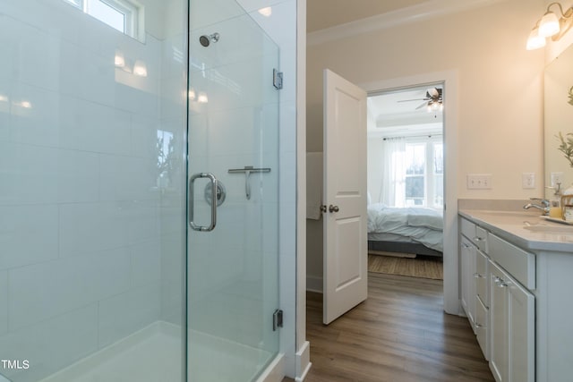 bathroom featuring a stall shower, ornamental molding, wood finished floors, and ensuite bathroom