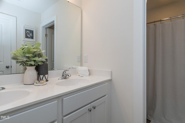 full bath with double vanity, a shower with shower curtain, and a sink