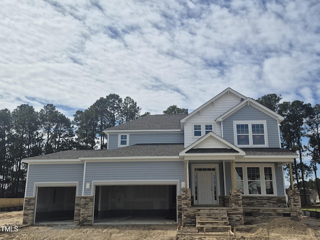 craftsman inspired home with an attached garage, stone siding, and roof with shingles