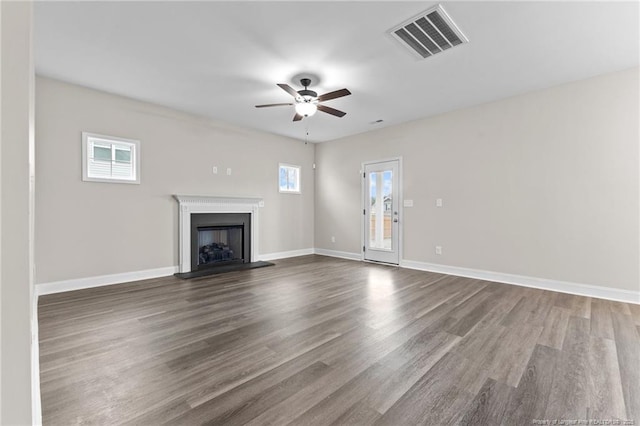 unfurnished living room featuring dark wood-type flooring and ceiling fan