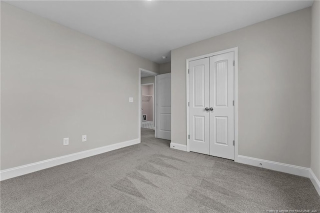 unfurnished bedroom with light colored carpet and a closet