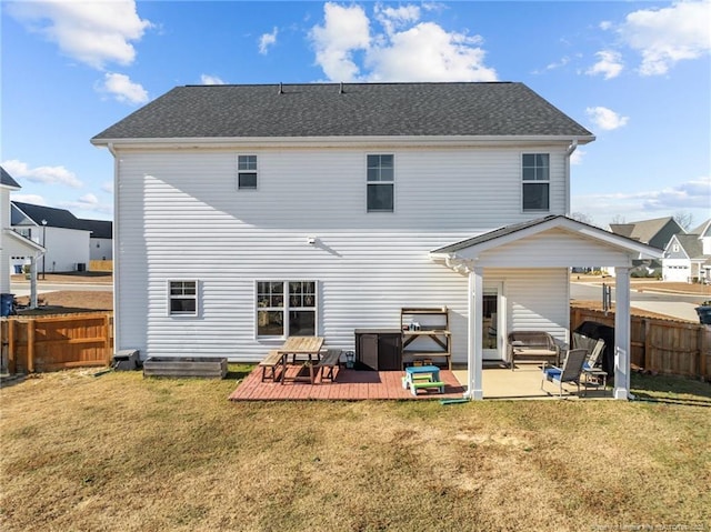 back of property featuring a wooden deck, a yard, and a patio area