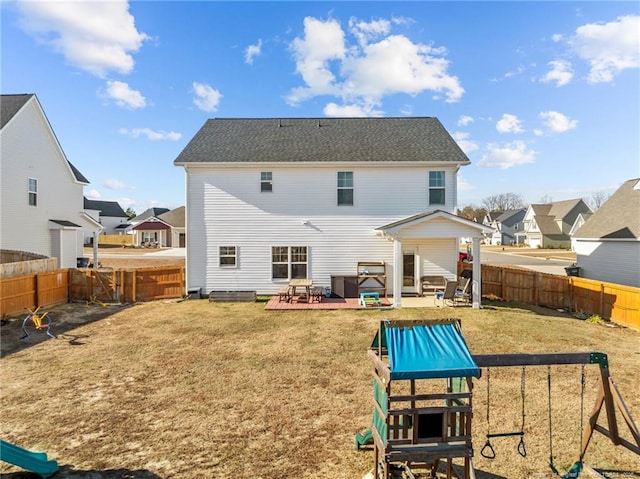 back of property with a playground, a patio, and a yard