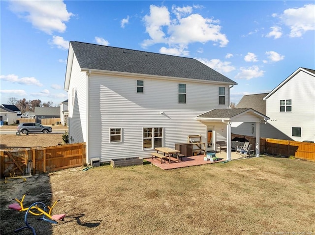 back of house with a patio and a lawn