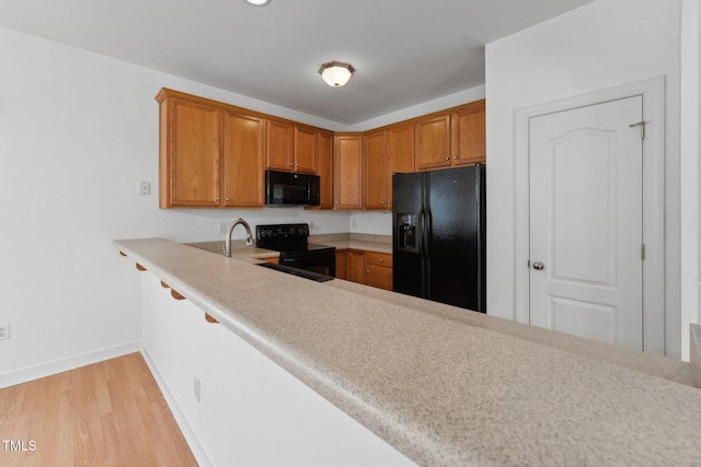 kitchen featuring black appliances and light wood-type flooring