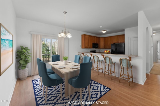 dining room with a notable chandelier and light wood-type flooring