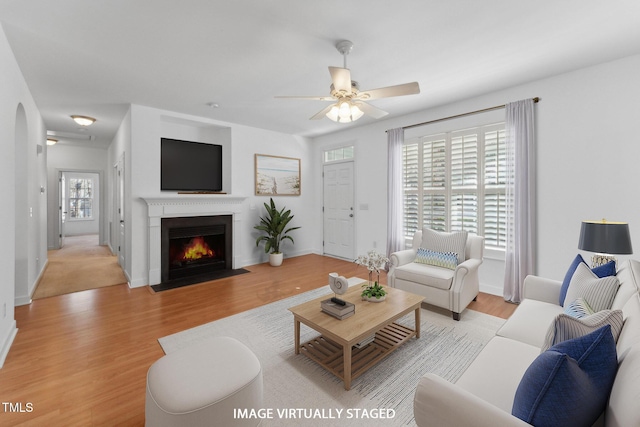 living room with ceiling fan and light wood-type flooring