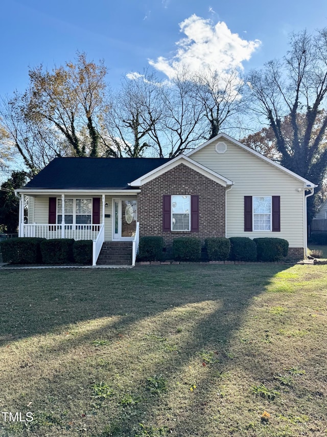 ranch-style home featuring a front lawn and covered porch