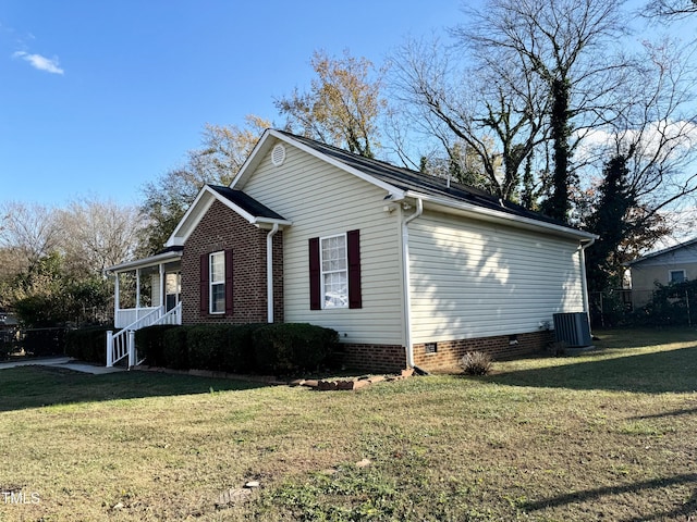 view of side of home featuring central AC unit and a lawn