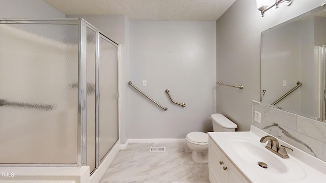 bathroom featuring vanity, toilet, a shower with door, and a textured ceiling