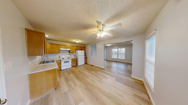 kitchen with a textured ceiling, sink, light hardwood / wood-style floors, and white appliances