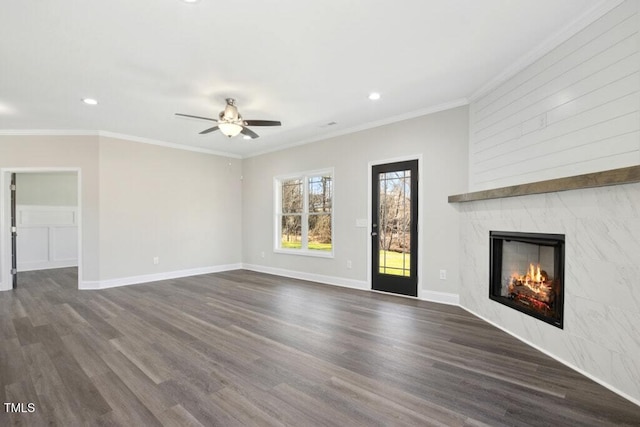 unfurnished living room featuring dark wood-type flooring, ornamental molding, and a premium fireplace