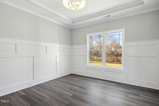 unfurnished room with dark hardwood / wood-style flooring, a notable chandelier, a tray ceiling, and ornamental molding