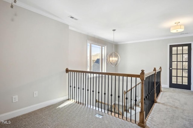 hallway featuring an inviting chandelier, crown molding, and carpet