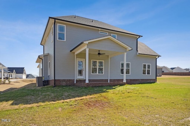 back of property with a yard, central AC unit, and ceiling fan