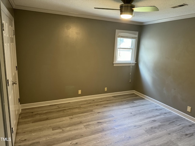 empty room with a textured ceiling, light wood-type flooring, ceiling fan, and crown molding