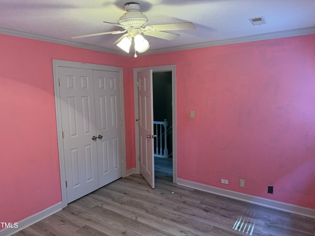 unfurnished bedroom with a textured ceiling, light hardwood / wood-style flooring, ceiling fan, and ornamental molding