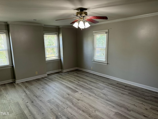 empty room featuring ceiling fan, light wood-type flooring, and ornamental molding