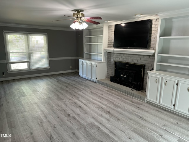 unfurnished living room with light wood-type flooring, a brick fireplace, ornamental molding, built in shelves, and ceiling fan