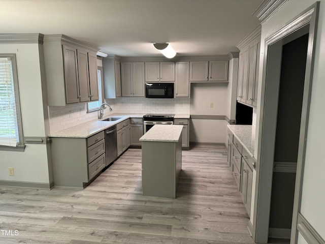 kitchen featuring appliances with stainless steel finishes, a center island, a healthy amount of sunlight, and sink