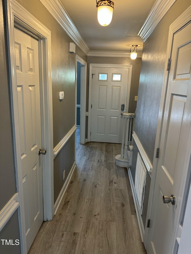 entryway featuring wood-type flooring and crown molding