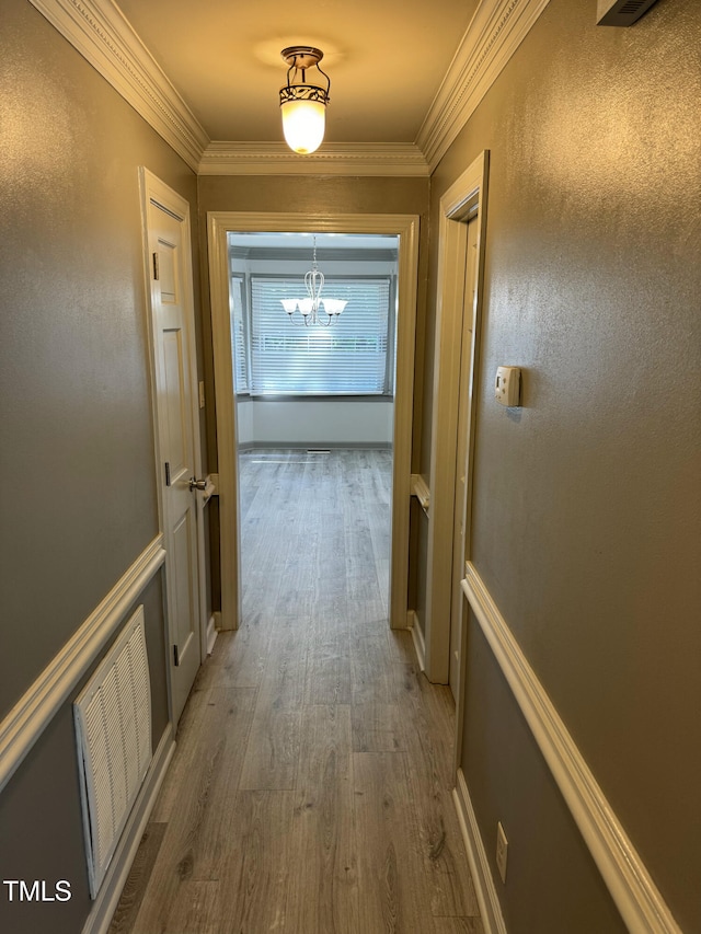 hall featuring dark hardwood / wood-style flooring, ornamental molding, and a chandelier