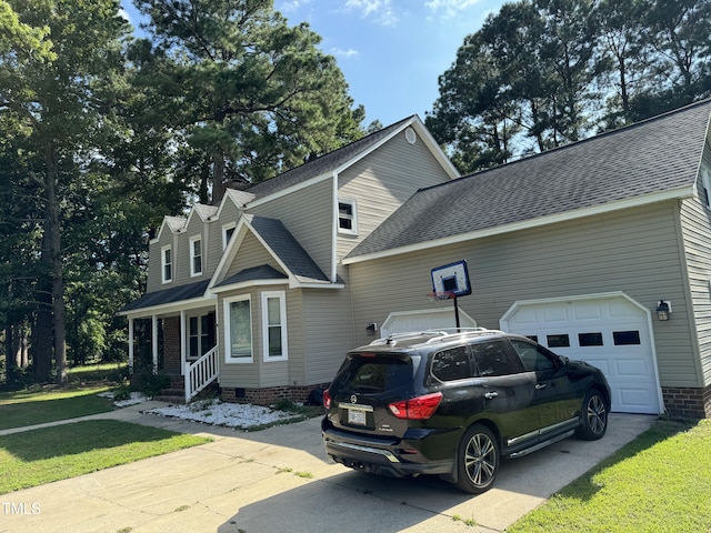 view of side of home featuring a garage and a lawn