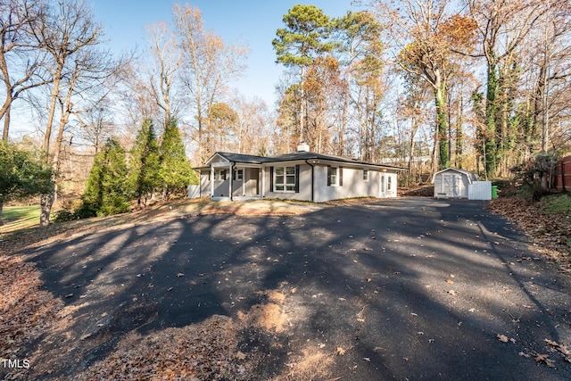 view of front facade with a porch and a storage shed