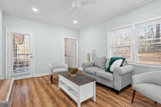 living room featuring hardwood / wood-style flooring, ceiling fan, and crown molding