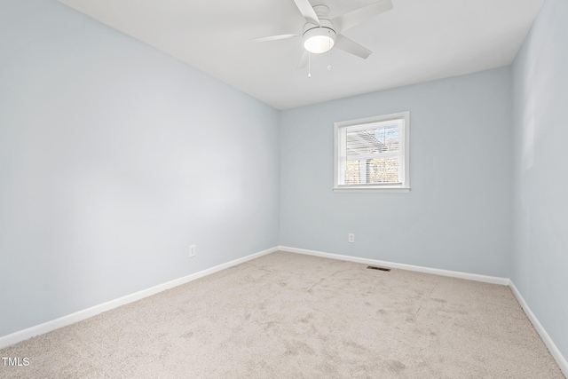 spare room featuring light carpet and ceiling fan