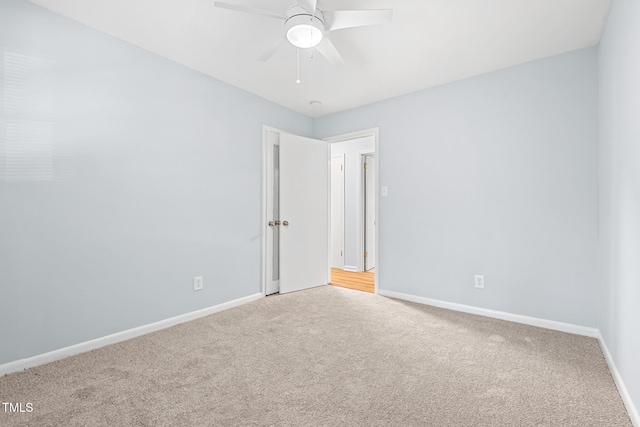 carpeted spare room featuring ceiling fan