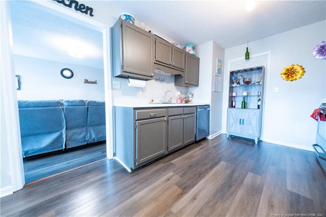 kitchen featuring a textured ceiling, dishwasher, dark hardwood / wood-style floors, and sink