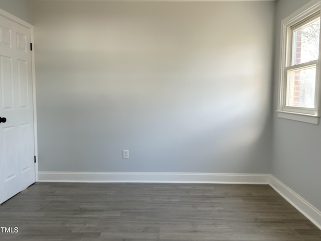 empty room with dark hardwood / wood-style flooring