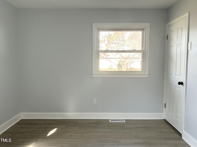 spare room with dark wood-type flooring