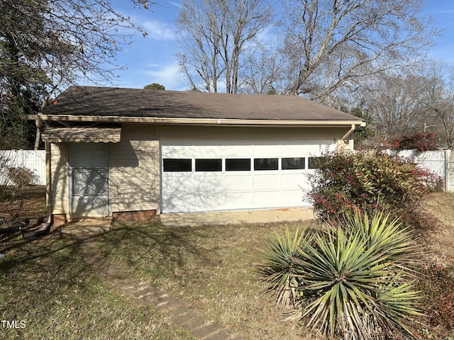 exterior space featuring a lawn, a garage, and an outdoor structure