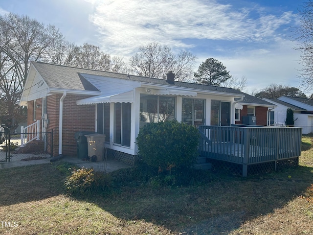 back of property with a yard and a wooden deck