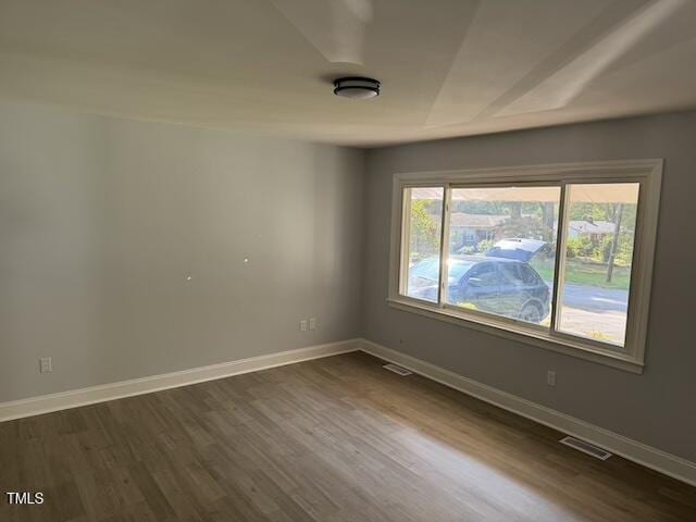 unfurnished room with dark wood-type flooring