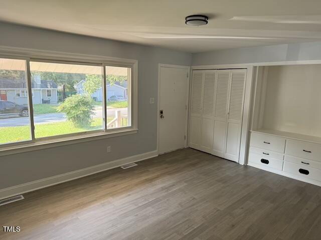 unfurnished bedroom with a closet and hardwood / wood-style flooring