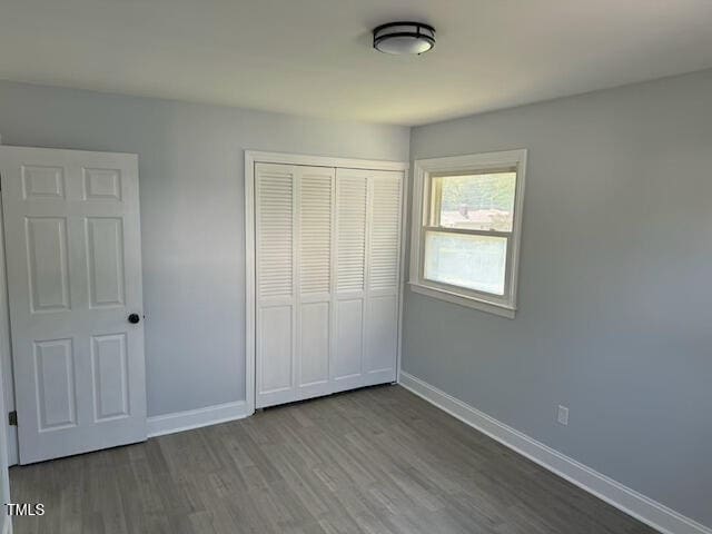 unfurnished bedroom featuring a closet and hardwood / wood-style floors