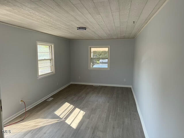 empty room with wood ceiling and wood-type flooring