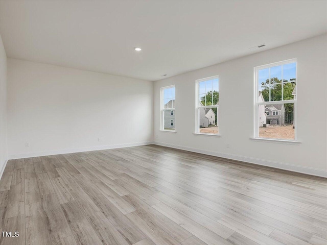 empty room featuring recessed lighting, baseboards, visible vents, and light wood finished floors